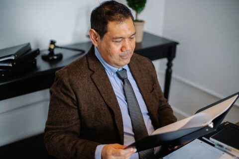 Man in business attire reviewing documents at a desk
